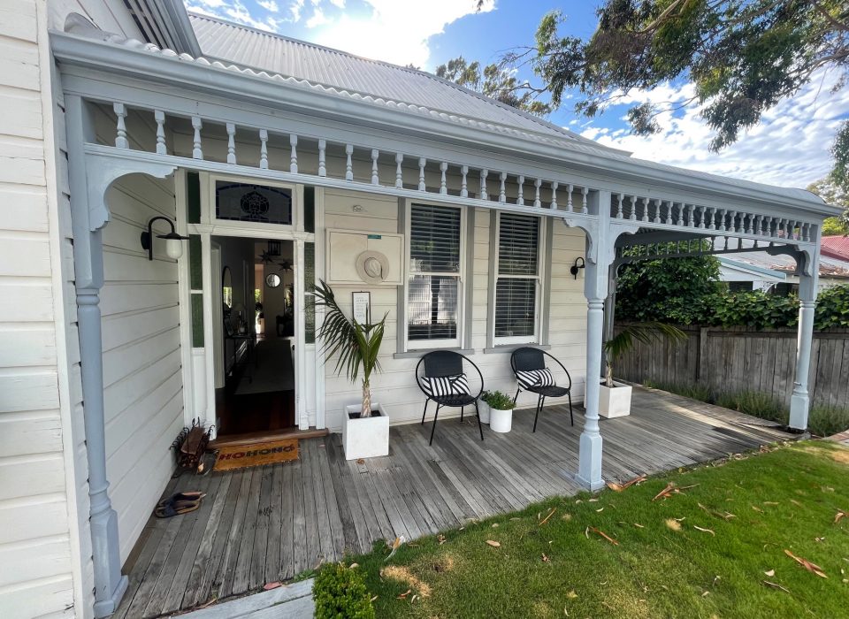 A worker's cottage-style home with a worn timber porch