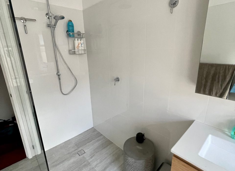 A renovated bathroom with a walk-in shower